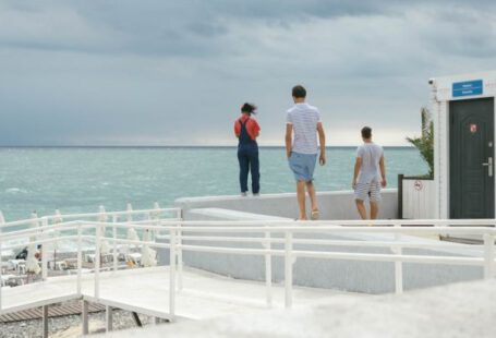 Water Features - Three People Standing on White Surface Near Body of Water