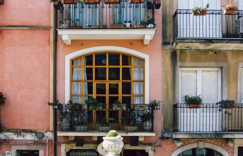 Window Boxes - a building with a balcony and a statue in front of it