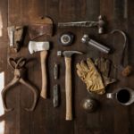 Hand Tools - clothes iron, hammer, axe, flashlight and pitcher on brown wooden table