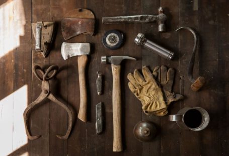 Hand Tools - clothes iron, hammer, axe, flashlight and pitcher on brown wooden table