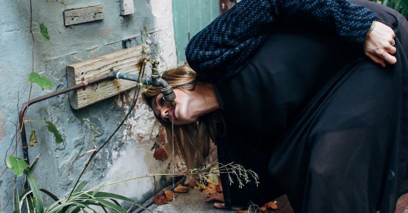 Drip Irrigation Systems - Woman drinking water from a Faucet